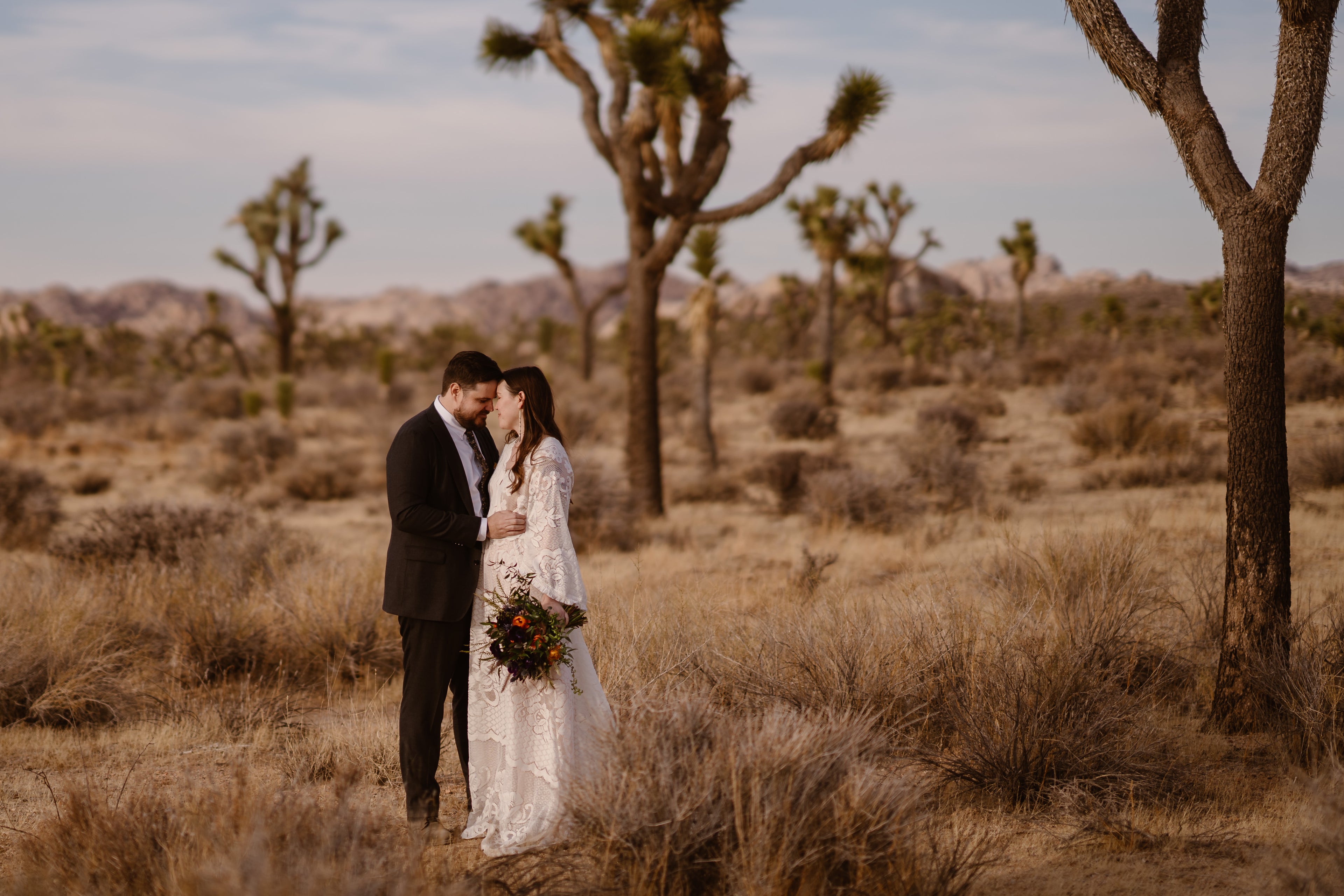 Couple holding wedding flowers at their desert elopement