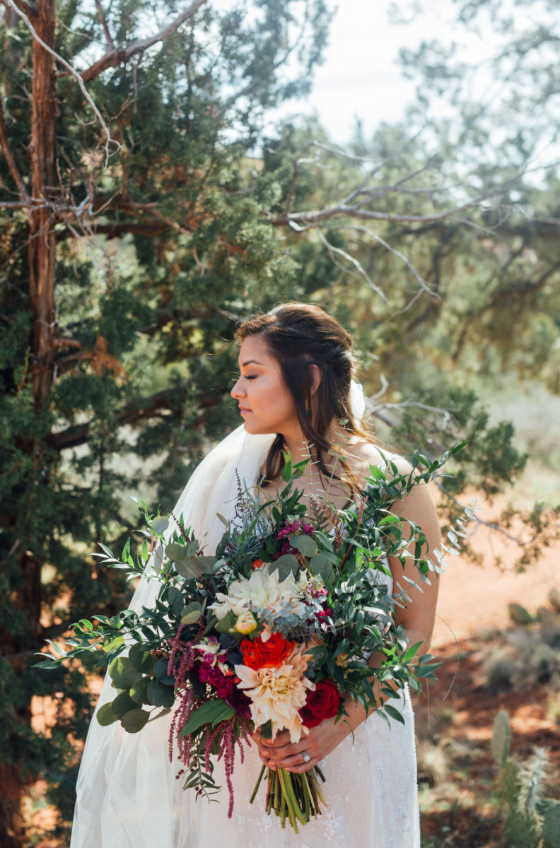 Bride holding large bouquet of brightly colored wedding flowers 