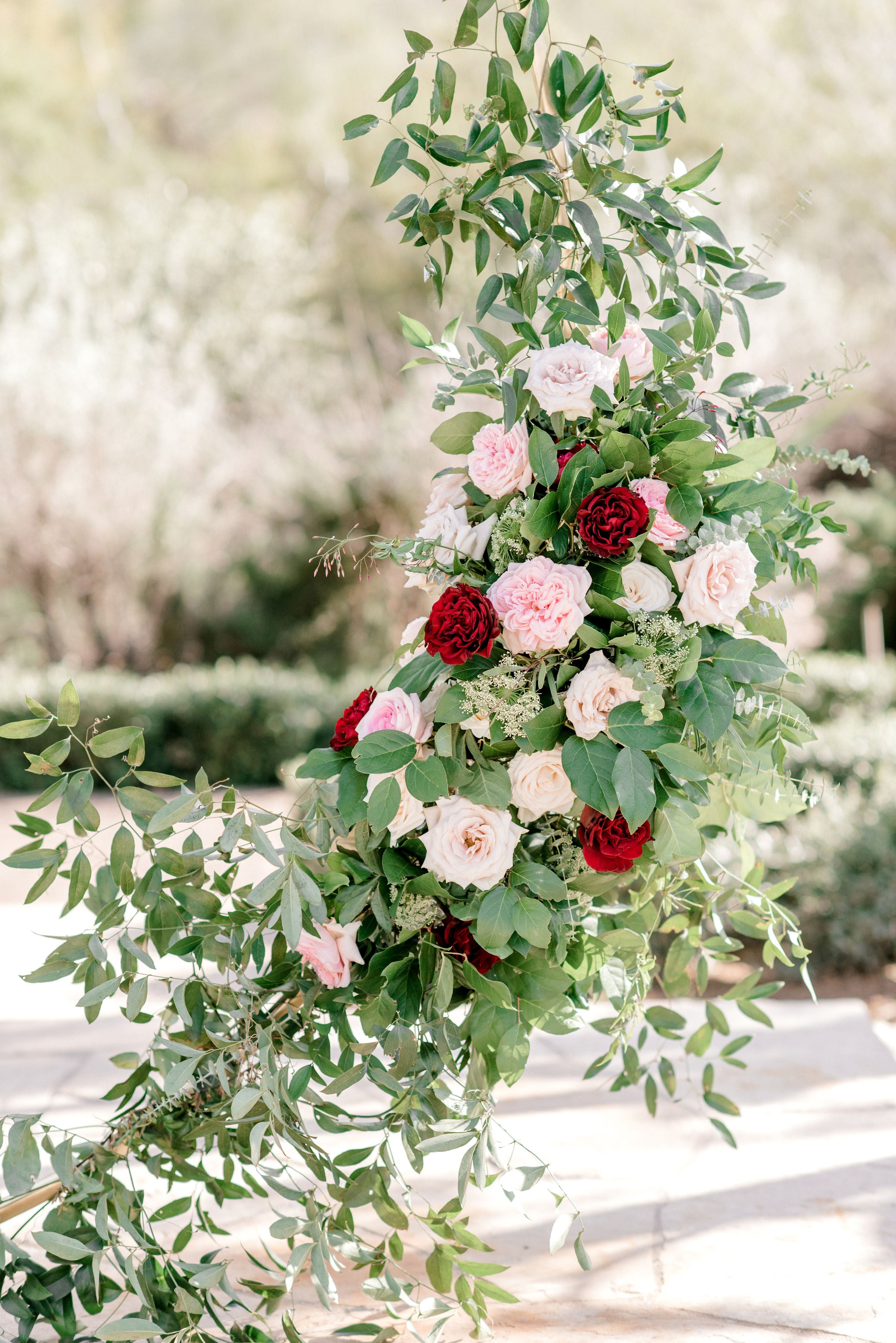 Ceremony floral arch containing smilax and roses